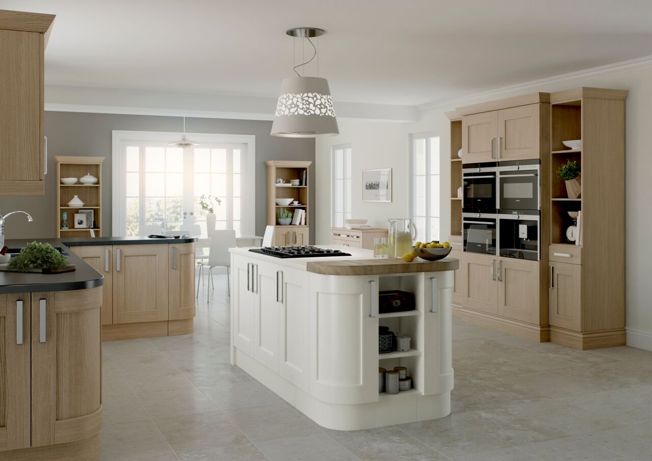 A cream shaker kitchen with a curved island and pendant lights above it